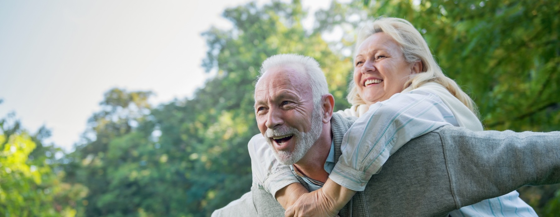 a man with a woman on his back outdoors