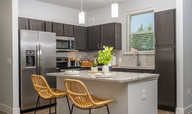 a kitchen with barstools, dark wood cabinets and stainless steel appliances