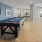 Resident lounge at our 55 and over apartments in San Antonio, TX, featuring wood grain floor paneling and a pool table.