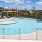The pool area at our 55 and over community in San Antonio, featuring umbrellas, beach chairs, and a hot tub.