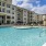 The pool area at our 55 and over community in San Antonio, featuring umbrellas, beach chairs, and a hot tub.